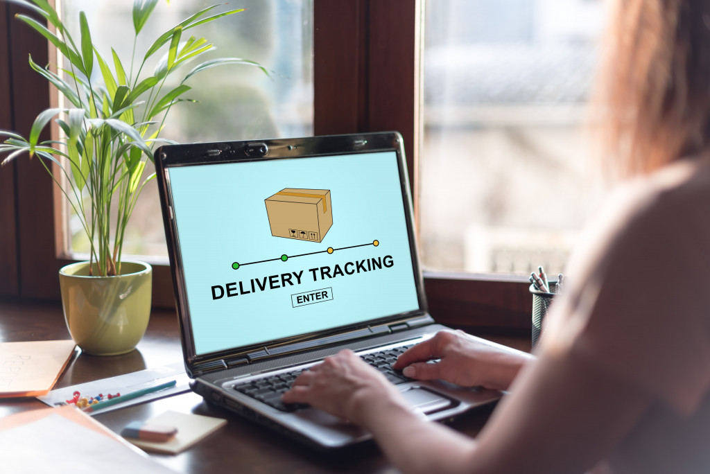 Rear view of a woman tracking delivery online on her laptop