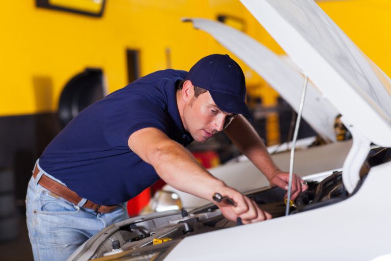 a car mechanic working on a vehicles motor